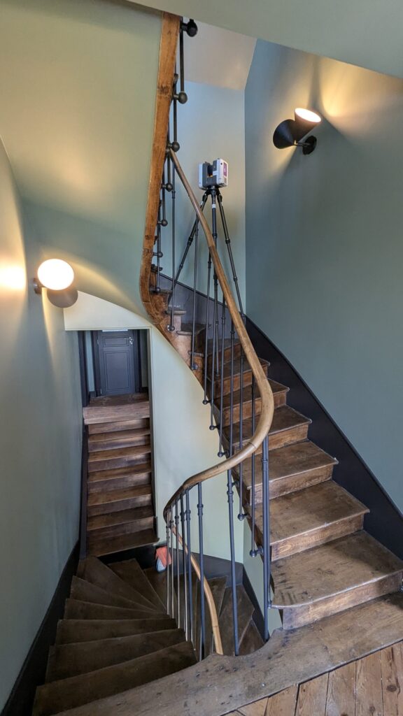 Escalier tournant en bois vu d’en haut, scanner laser sur le palier