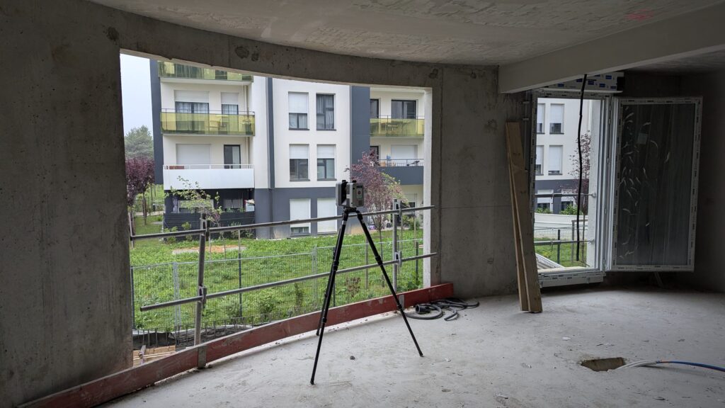 Scanner laser dans un logement en béton brut devant une baie, Aulnay-sous-Bois