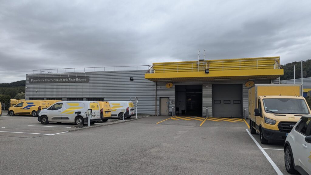 Quais de chargement et véhicules utilitaires devant un centre de tri de colis